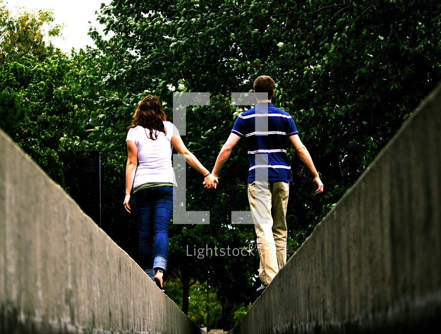 couple balancing walking holding hands 