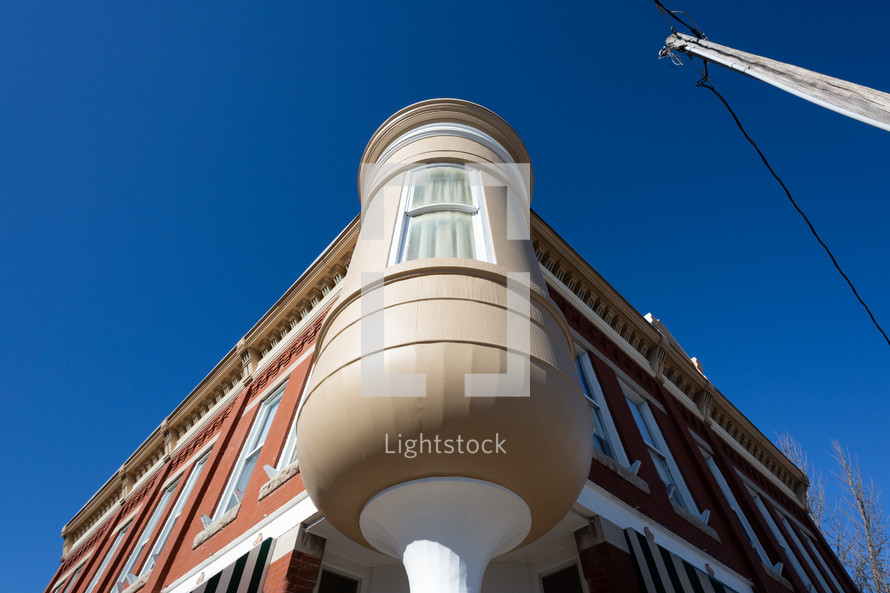 Red brick building with white rounded corner window