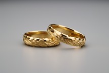 Sacrament: Matrimony. Two gold wedding rings on a gray background, close-up.
