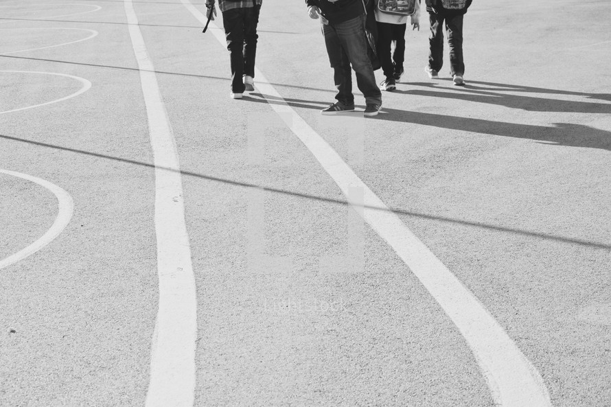 kids on a an asphalt court after school 
