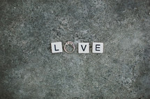 word love - scrabble pieces and an engagement ring