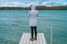 a woman standing on a dock in fall 