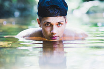 teen boy standing in deep water 