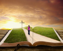 woman walking on a path towards the cross on a Bible