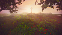 The cross of Jesus on a hill during sunrise on a pretty landscape