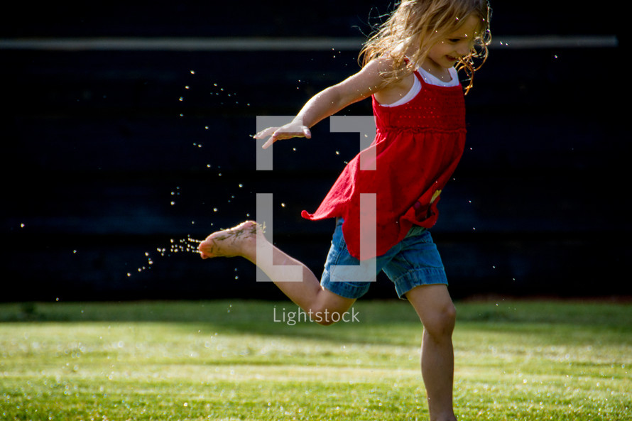 Child running and splashing in a mud puddle.