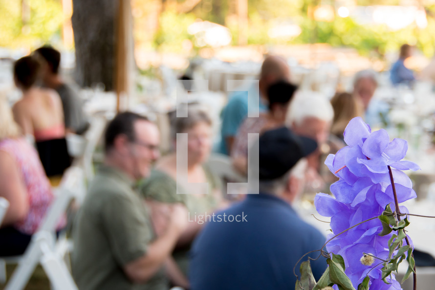 crowds at an outdoors dinner party 