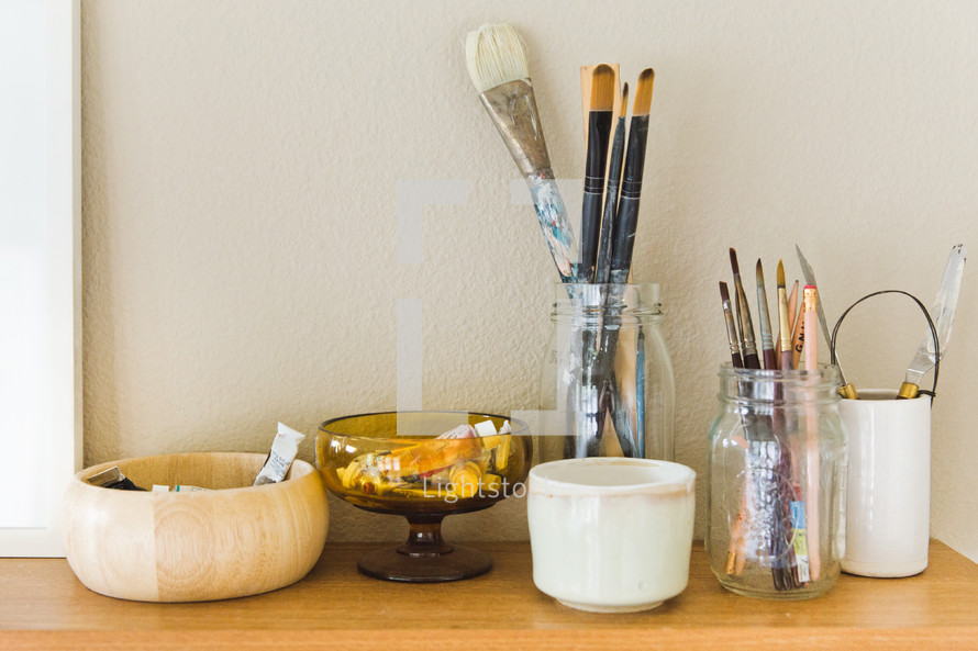 paint and paint brushes in jars 