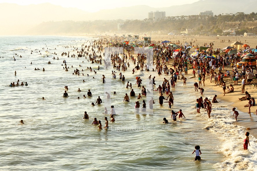 people in the ocean on a crowded beach 