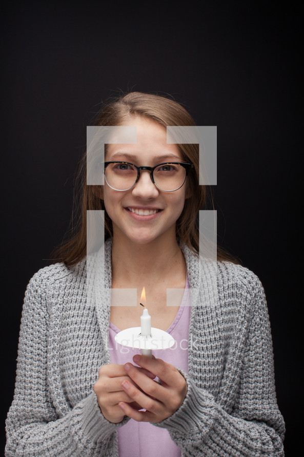 a teen girl holding a candle 