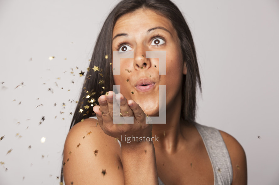 woman blowing confetti 