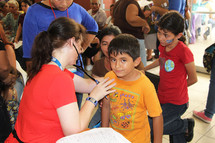 children receiving medical care from a doctor 