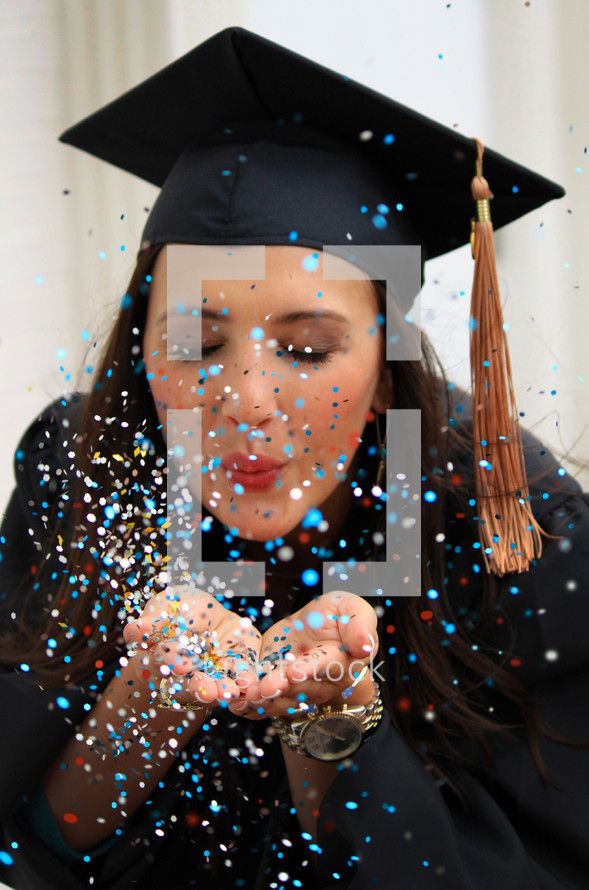 a female graduate blowing confetti 