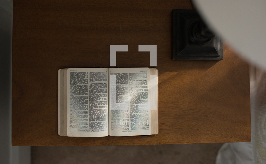 An open Bible on a wooden desk.