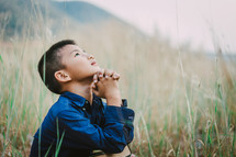 Child looking up to God in prayer 