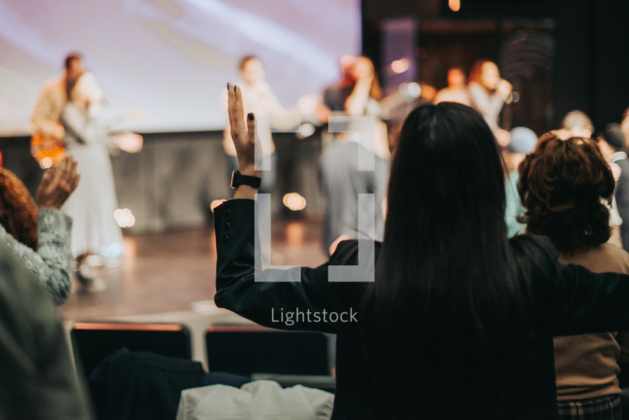 Woman with her hands raised during worship.