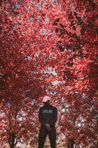 a man standing under vibrant fall leaves 