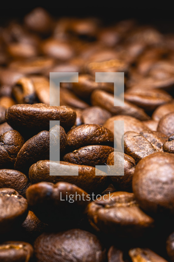 Close up from a bunch of coffee beans laying down. Backdrop for coffee products.