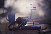 headphone cords in the shape of a cross on a Bible 