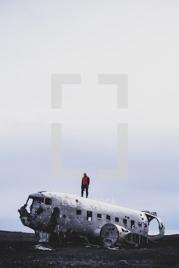 a man standing on the wreckage of an old airplane crash site 
