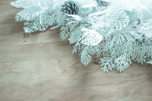 white Christmas greenery on a wood background 