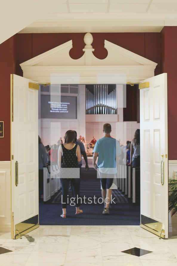 entering through doors into a church 