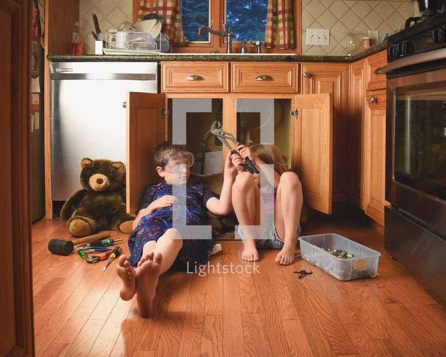 brother and sister fixing a kitchen sink 