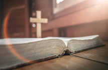 wooden cross on an open Bible 