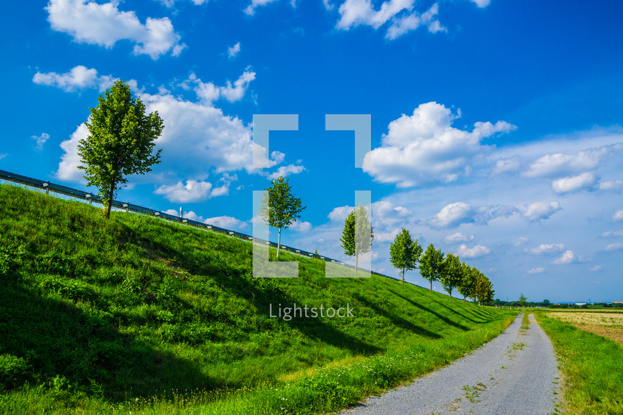 guard rail, trees, green, hill, grass, blue sky, summer, clouds, rural road