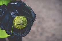 A baseball held inside a baseball glove.