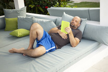 a man relaxing reading a book outdoors 