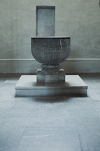 A stone baptismal font in an old cathedral 