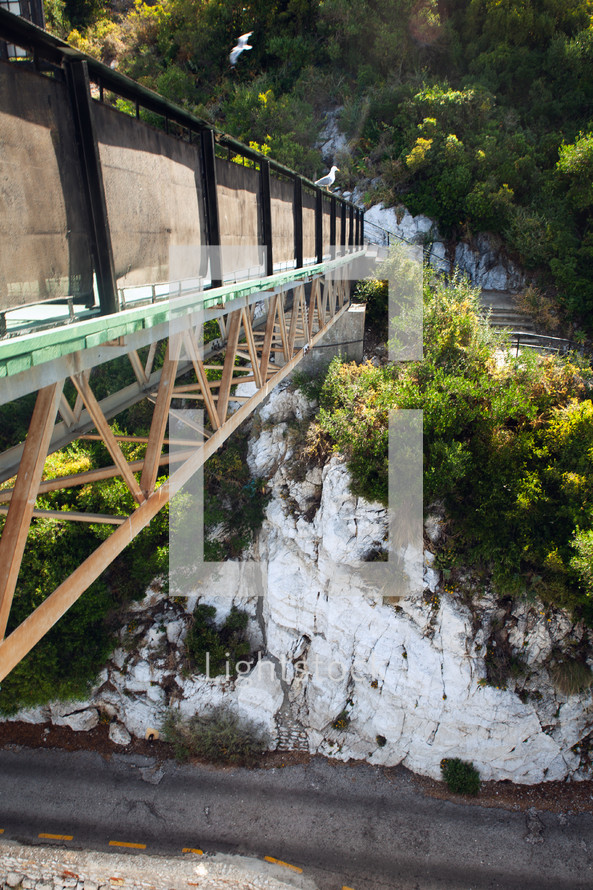 Seagulls perched on an industrial bridge in a rocky landscape