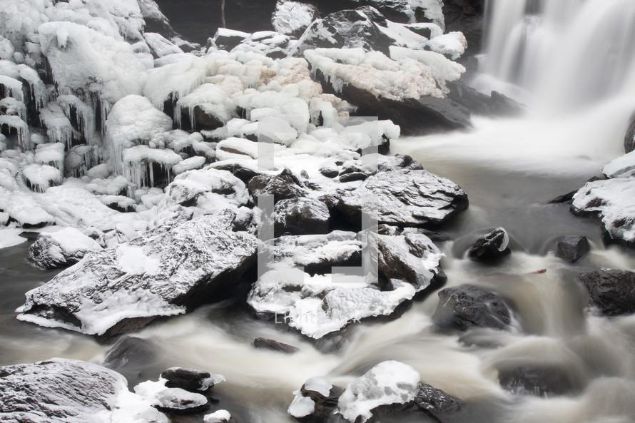 Waterfall into an icy stream.
