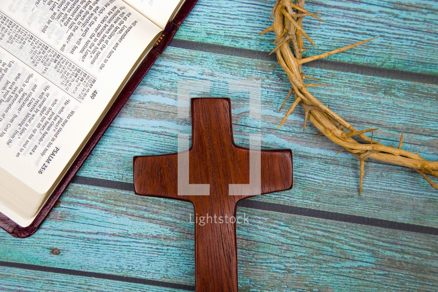 crown of thorns, wooden cross, and open Bible  