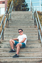 a young man sitting on concrete steps 