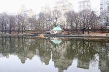 reflection of city buildings on pond water 