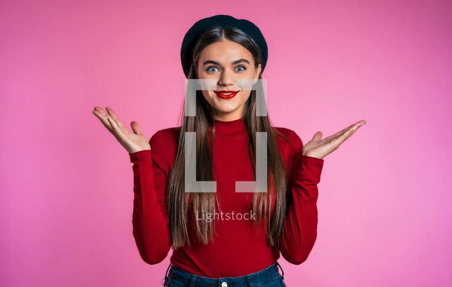 Excited happy woman. Female shocked model on pink background. Pretty woman with perfect make-up, stylish outfit pleasantly surprised.