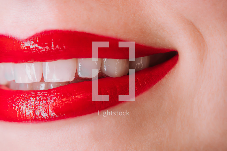 Woman with red liquid lipstick or gloss. Shiny smile. 