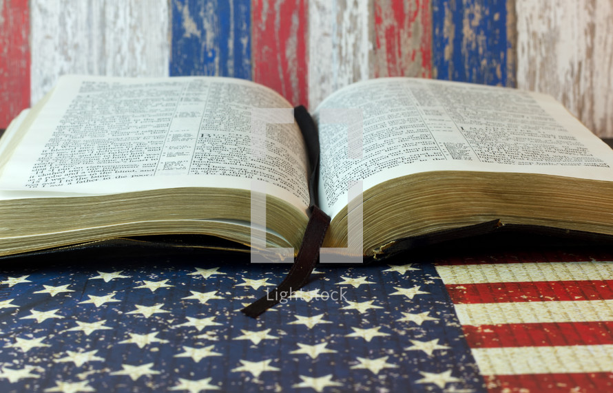 An open Bible on an American flag.