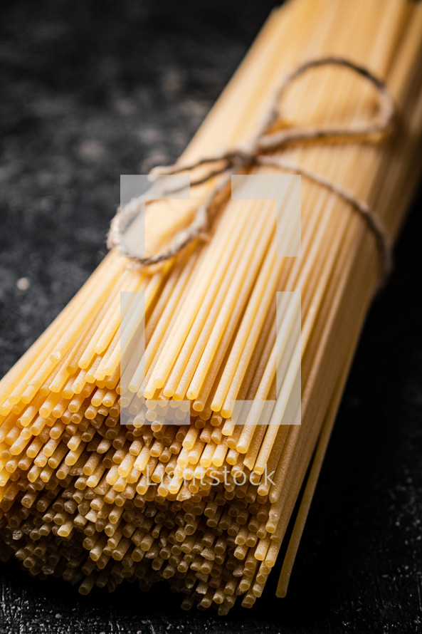 A pile of spaghetti dry on the table. Against a dark background. High quality photo