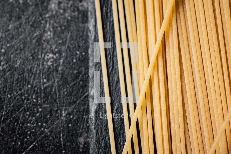 A pile of spaghetti dry on the table. Against a dark background. High quality photo