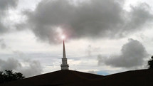 A Church Steeple towers among the darkness creating a beacon of light that draws souls from the darkness to the light of the world. This metaphor is being illustrated here in this image as the church is the house of God where people come to Christ and be drawn to the light of the world, Jesus. 