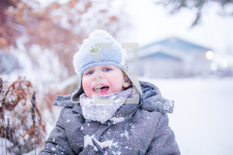 a boy child playing outdoors in snow 