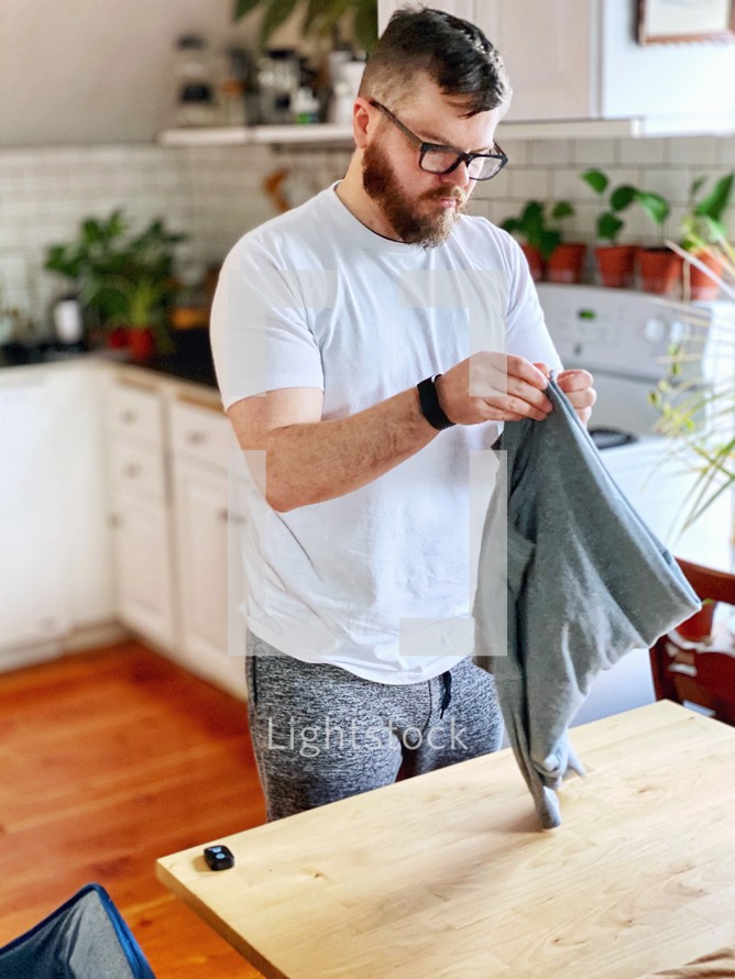 a man folding laundry 
