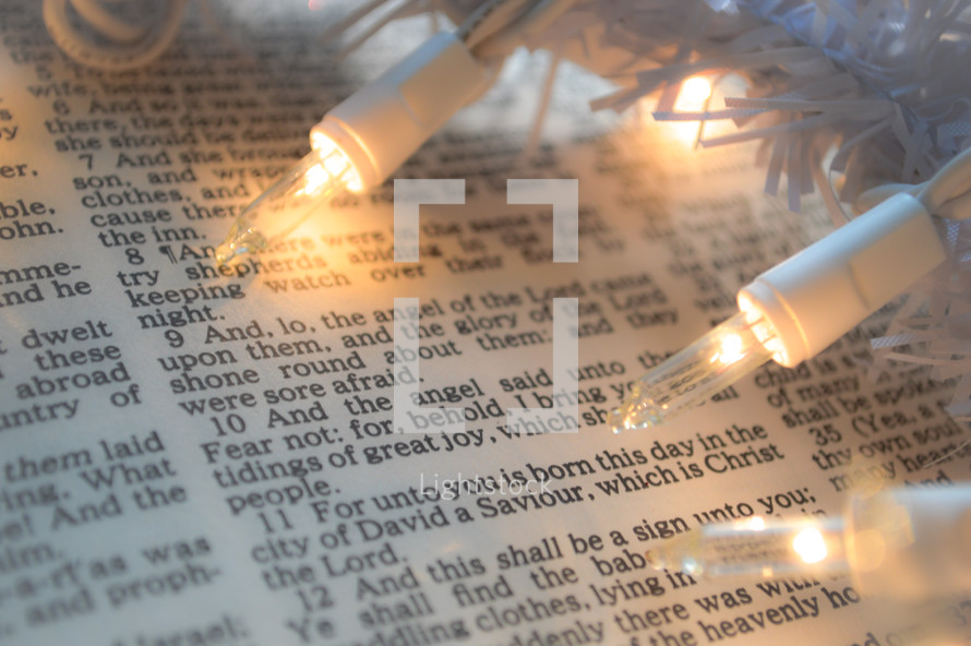 Christmas lights on the pages of a Bible 