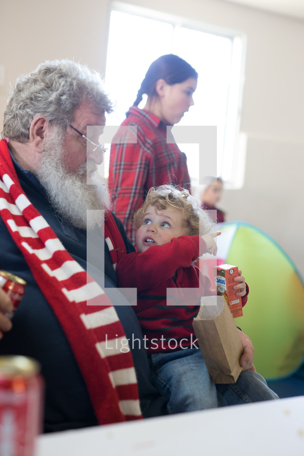 happy toddler sitting on grandfather's lap