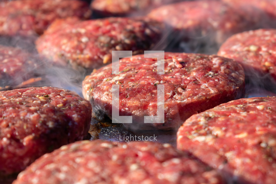 raw hamburger meat on a grill 