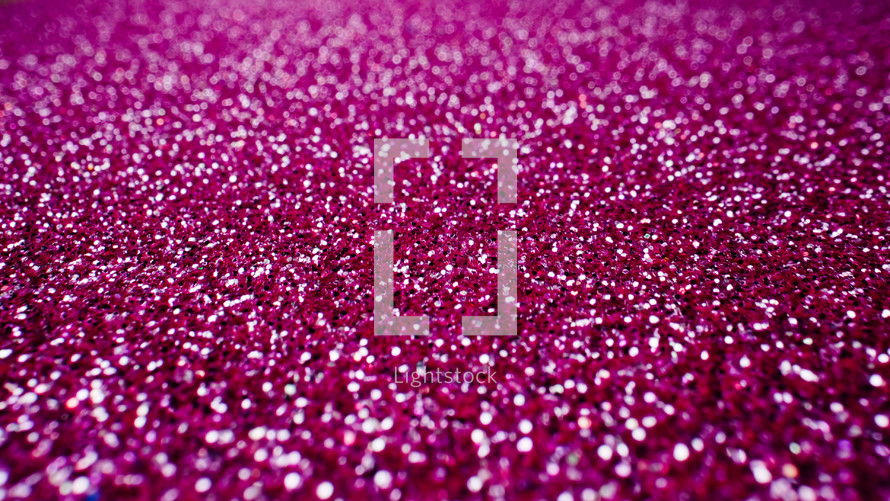 Abstract pink background with shining sparkles. Glittering Particles surface. Festive dust. Beautiful texture, bokeh. New Year party concept.