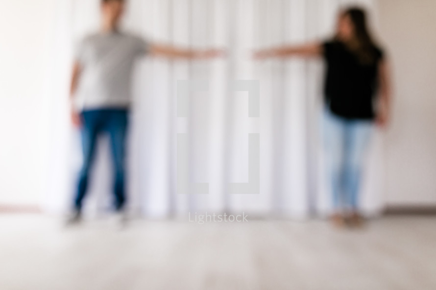 blurring image of a couple reaching for each others hands 